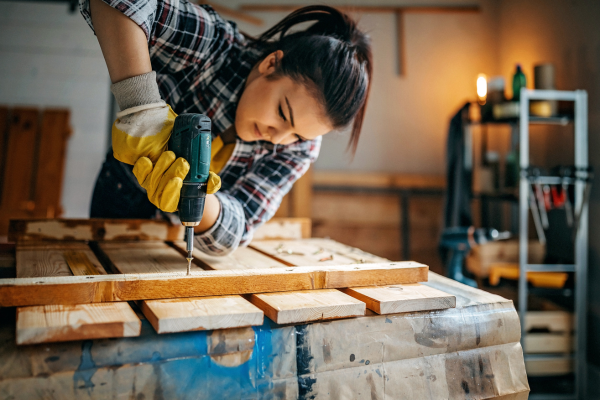 Power drill being used on lumber project in a garage